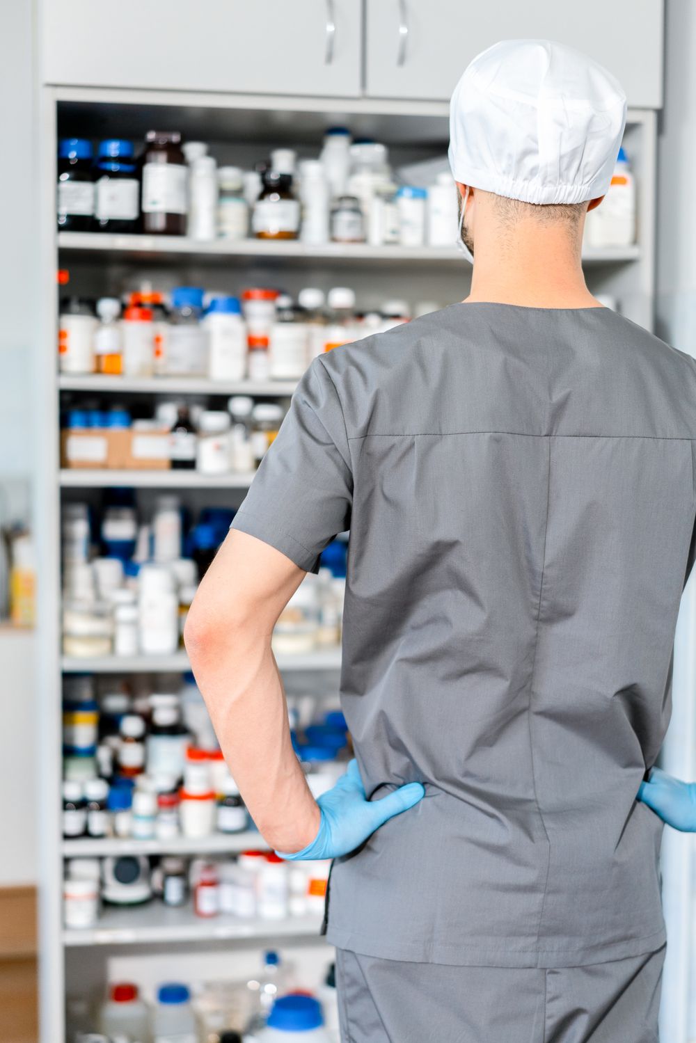 A pharmacist organising medication on pharmacy shelves
